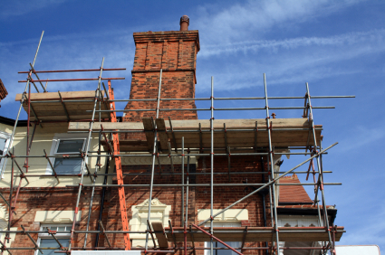 upward view of scaffolding surrounding a brick building